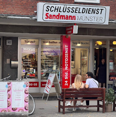 Außenansicht des Geschäfts Schlüsseldienst Sandmann Münster mit Ladenschild und Schaufenster 